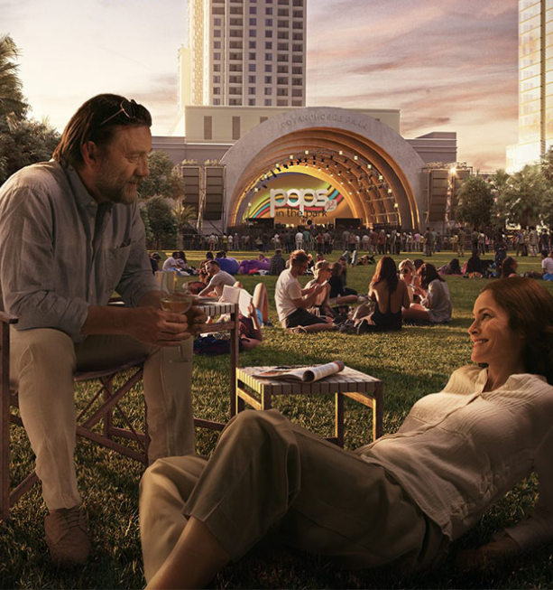 man and woman in grass at a concert at an amphitheater
